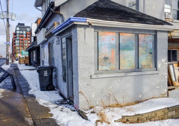 old building, cafe, on Kingston Road with painting in the covered windows, redevelopment notice on front, snow on ground
