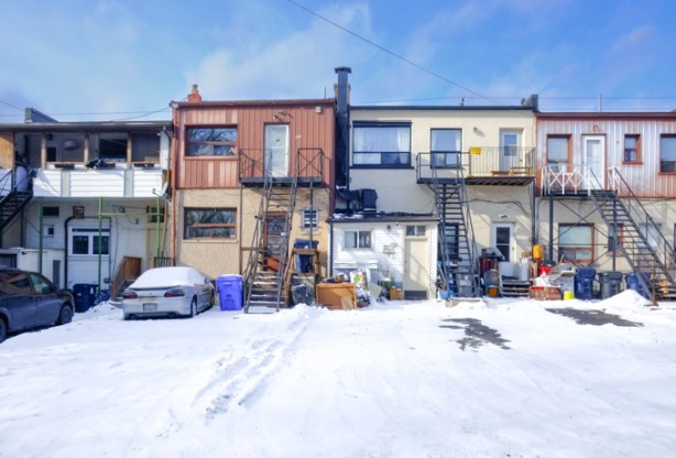 snow covered lane, back of stores and buildings on Kingston Road, two storey, exterior stairs, porches, balconies, doors, and windows,