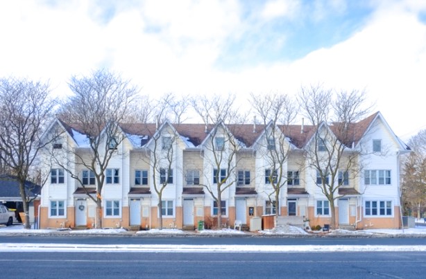 rowhouses on Kingston Road three storeys high, with trees in front,