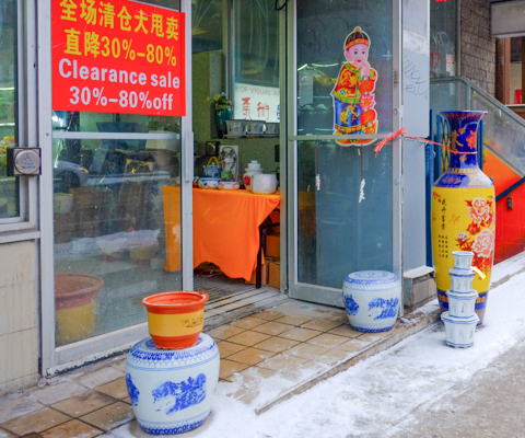 outside asian store, door open, ceramic pots for sale, clearance sale sign in window