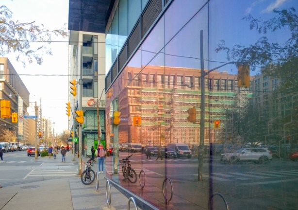 reflections in a large window at dundas and jarvis, showing 222 Jarvis, inverted ziggurat building being renovated,