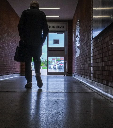 silhouette of man walking down hallway at wilson station, light coming through the door at the end of the passage, exit to wilson heights side of the station