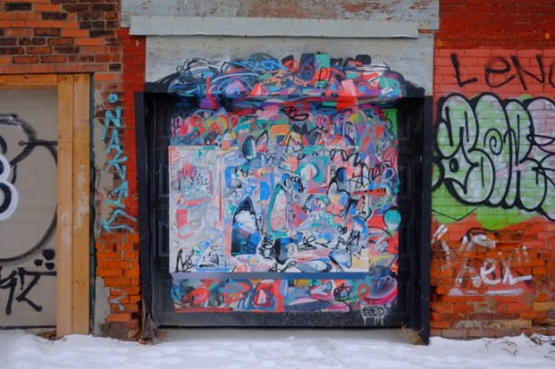 street art mural by Mony Zakhour in alley behind Dundas West on garage door 