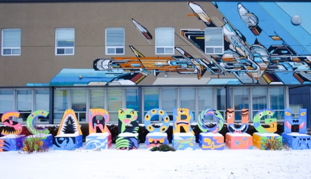 mural, drift appendar, by mediah alias Evond Blake, on the side of a two storey building in Scarbourgh. in front of the building is the word scarborough, each letter make with animal like character in the shape of that letter.