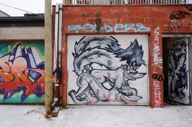 black and white mural on a garage door of at least three wolf-like creatures