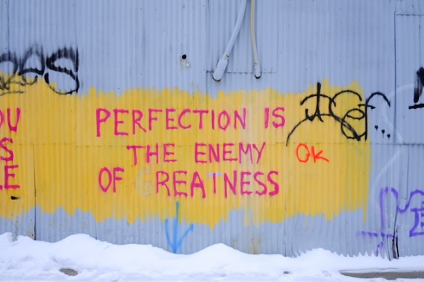 text graffiti that says perfection is the enemy of greatness