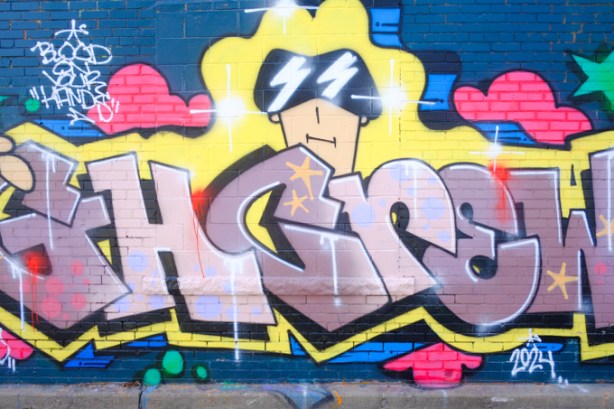 throw up tag street art for g h crew, with one cartoon like character with black cap, lightning eyes, also text that says blood on your hands