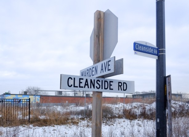 city street signs on a stop sign pole, cleanside road and warden avenue, vacant lot behind