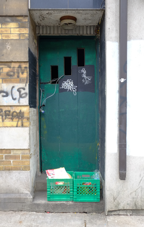 green door, with 2 green milk crates sitting on the doorstep