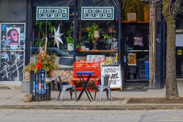 from across the street, front of Grocery Coffee with a table and two chairs outside