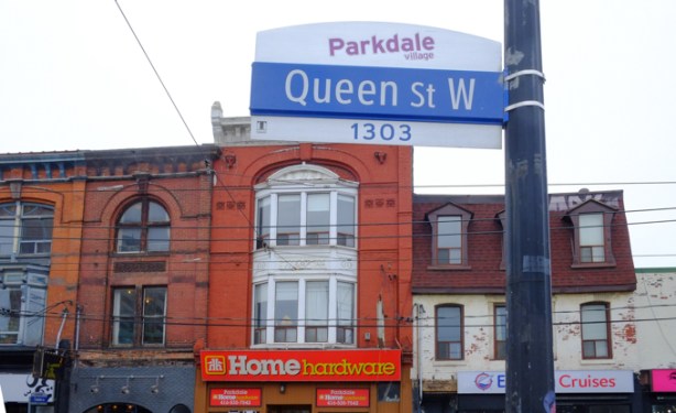 toronto city street sign, Queen Street West, Parkdale, showing the upper level of the buildings across the street