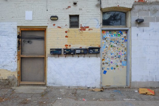 2 doors on a building, the one on the right is covered with stickers