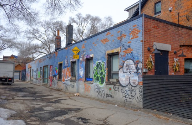 alley, long low building on right hand side, painted blue, with windows, 