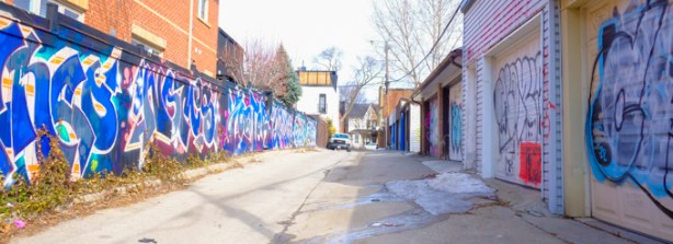 toronto alley near ossington with street art on fences and garages