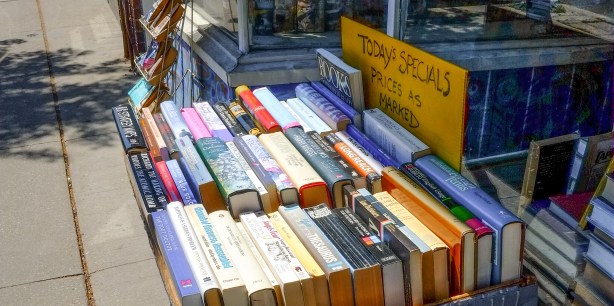 outside a book store, on a table, books for sale, with sign that says Today's Specials, prices as marked
