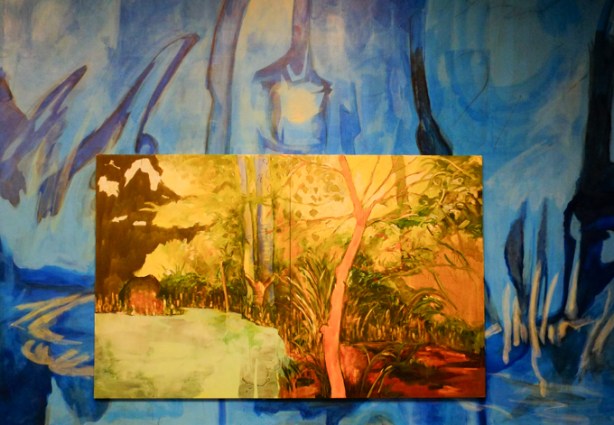 night garden effect, paintings by Emmanuel Osahor, walls painted in garden scene in blues, other paintings of outdoor garden scenery hung on top of the blues