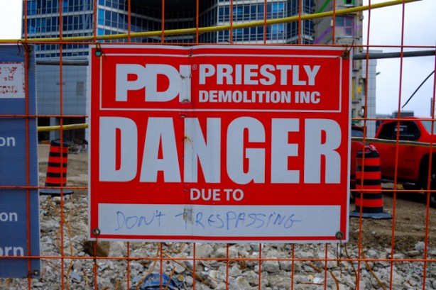 red and white danger sign with due to written in as don't trespassing