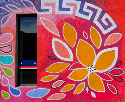 stylized orange flower petals on a red wall, mural, around a window,