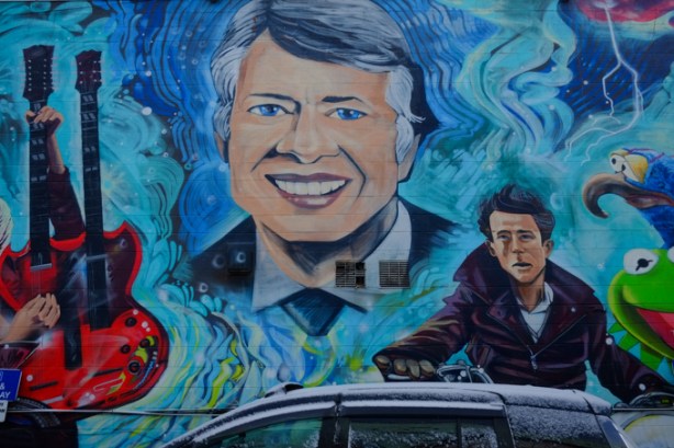 images of famous Jimmys on the side of Jimmys coffee shop on Ossington, Jimmy Carter, James Dean, the guitar of Jimmy Hendrix and two muppets representing Jim Henson gonzo and elmo