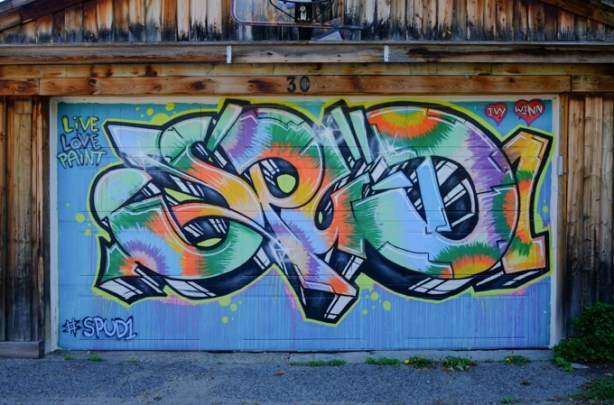 spud mural on a garage in an alley, with text, live, love, paint,