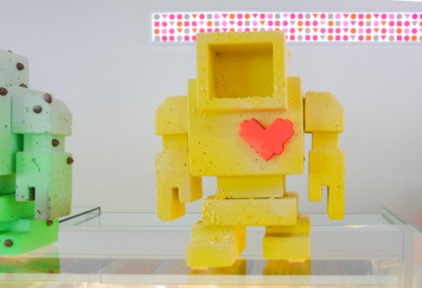 a yellow lovebot sculpture, with a red heart, on the counter at Nadege bakery