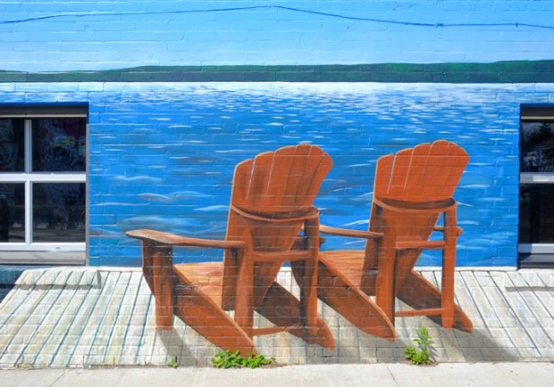 mural of two muskoka chairs on a dock by the lake