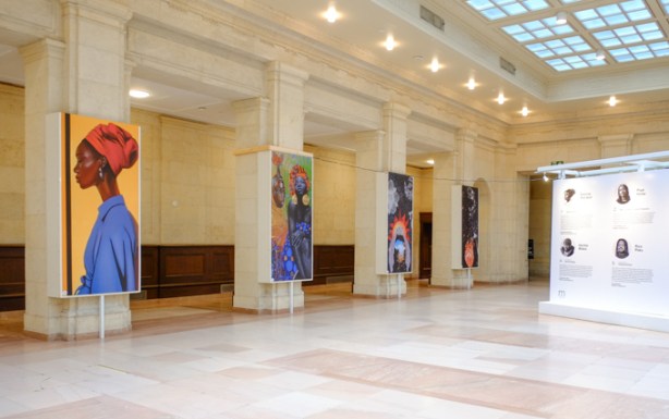pillars in large open hallway at union station, each with a large artwork displayed on them. Transit through time installation