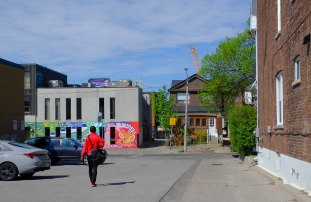 a man walks through an alley, and parking lot