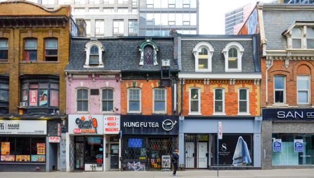 old brick buildings with mansour roofs, on Yonge, north of Wellesley, west side of the street, three storeys high, most from the 1880s, Kung Fu Tea, a chicken restaurant with bricks painted pink,
