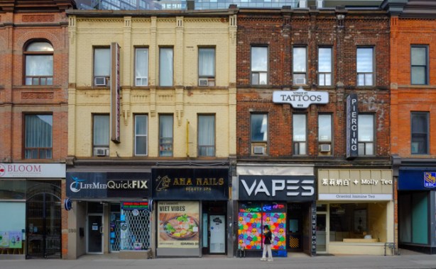 old brick buildings with flat roofs, on Yonge, north of Wellesley, west side of the street, three storeys high, most from the 1880s, Life Med quick fix, a vapes store, tattoo parlor, Molly Teas, and Ana Nails,