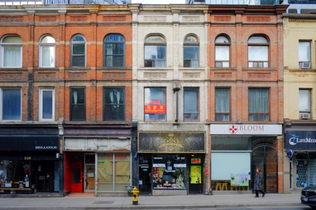 old brick buildings on Yonge, north of Wellesley, west side of the street, three storeys high, most from the 1880s, flat roof. Bloom clinic, a spa, an empty store with brown paper covering the window, 
