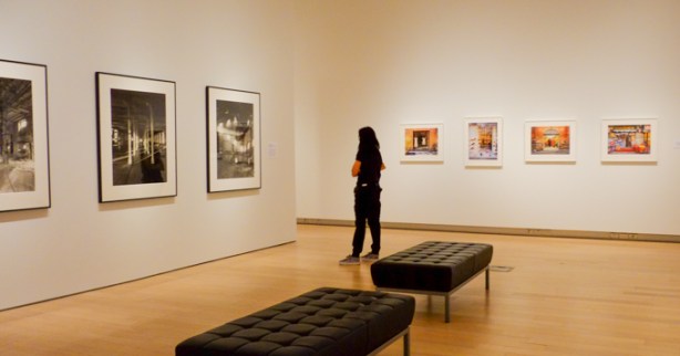 a woman looks at framed photographs on a gallery wall, TMU Image Centre gallery, Clara Gutsche show