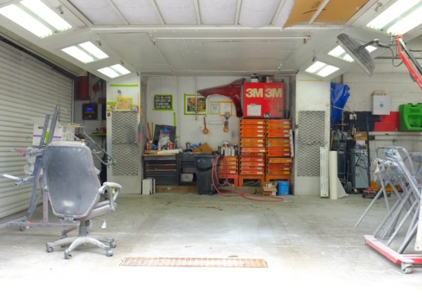 looking in through open door of mechanic's garage, swivel chair, shelves of tools 