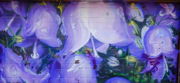street art mural artwork on a garage door, all purple flowers