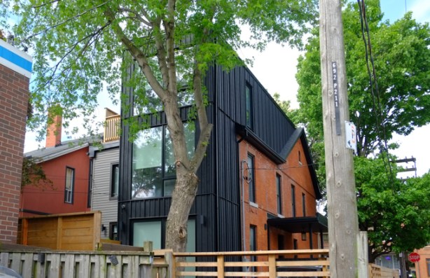 new addition to a house, with black cladding, older part of house is red brick