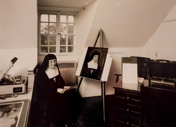 black and white photo from convent series by clara gutsche, nun with painting, on display at TMU Image Centre
