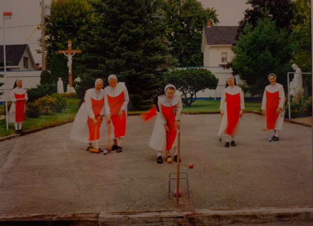 framed colour photo from convent series by clara gutsche, nuns in red playing croquet outside