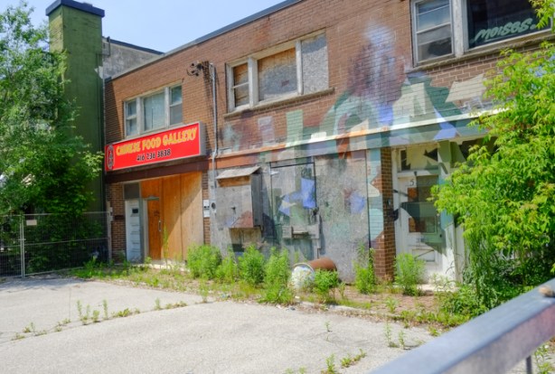 two storey building, with sign, chinese food gallery, now all boarded up, with mural on the front as well
