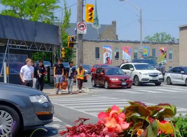 intersection of Dundas West and Cordova and Burnhamthorpe Road, people waiting to cross intersection, with crossing guard