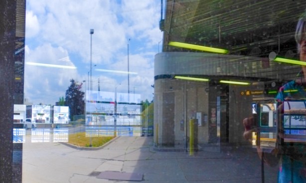 looking in the windows of lawrence east rapid transit station, now empty, reflections of outside as well