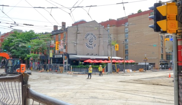 looking southeast at the corner of king and church streets, workmen on the road, pavement removed, closed to traffic,