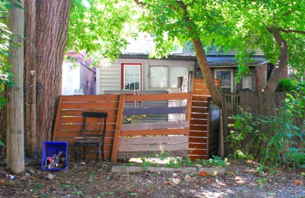 back of house, alley view, painted wood fence, lots of trees