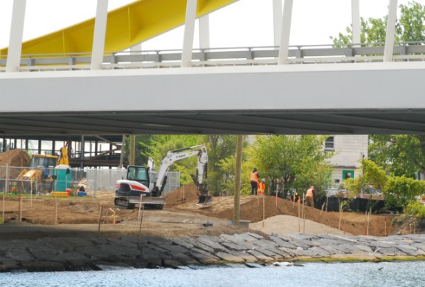 constuction, workmen and equipment, working along the banks of the new mouth of the Don River, as seen from under the yellow bridge