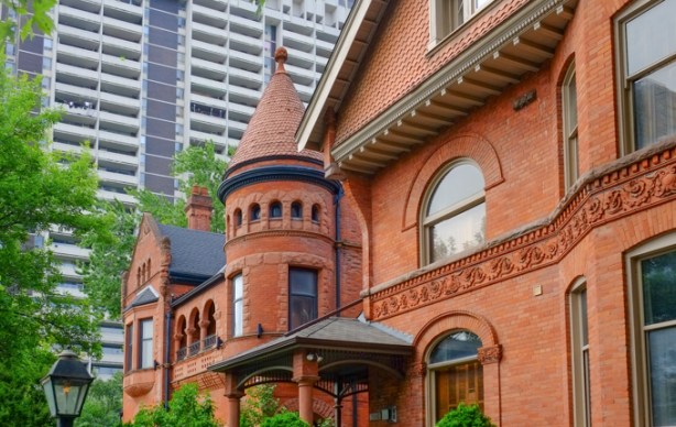 older brick building with fancy brick work, rounded windows, and a turret