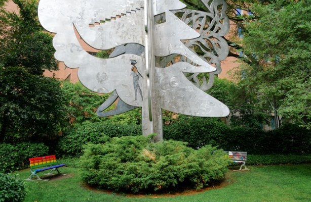 ishkozi park on huntley street, with large metal sculpture, and rainbow painted benches