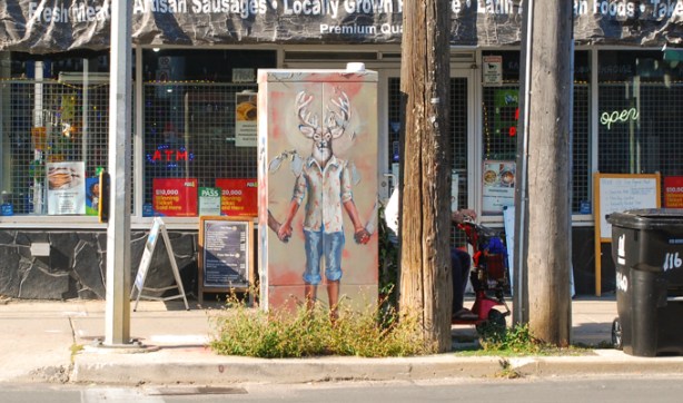 painting on sidewalk traffic box, in front of store, on Queen Street East