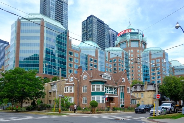 older brick residences on a side street near Jarvis and Bloor, with large Rogers headquarters building behind