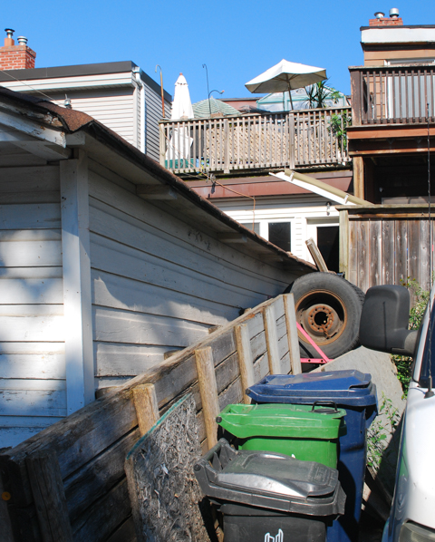 backyard alley views, old tire, trash bins, rooftop terrace with umbrella