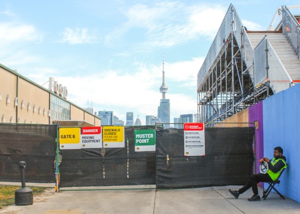 food building in background, as is CN Tower, entrance to construction site for renovations of BMO Field soccer 