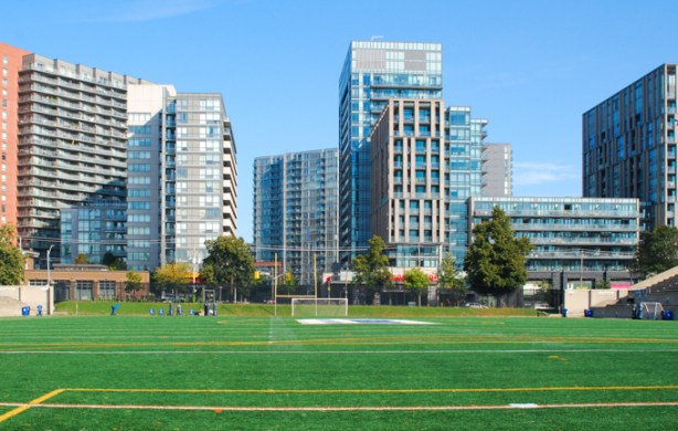view across the field of Allan Lamport stadium, looking north to wall of condo towers